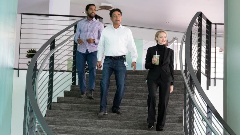 两名穿着牛仔裤的男子和一名穿着黑色高领毛衣和配套裤子的女子从办公空间的楼梯上下来;《辍学者》剧照