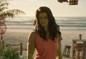 一个高个子女人，有着波浪般的黑发和绿色的皮肤，站在海滩上;《女绿巨人:律师》剧照